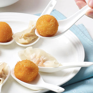 Spoonfuls of fried balls and dumplings on a white plate with a blue napkin.