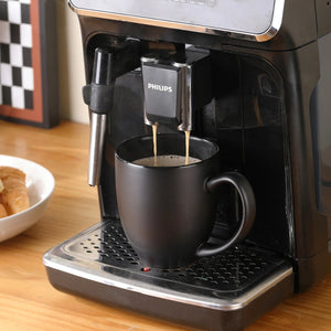 A stream of coffee flows from the machine into coffee mug matte black