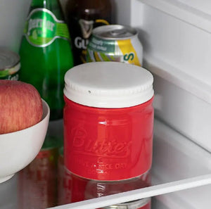 Red Butter container with a white lid on a refrigerator shelf with various items.