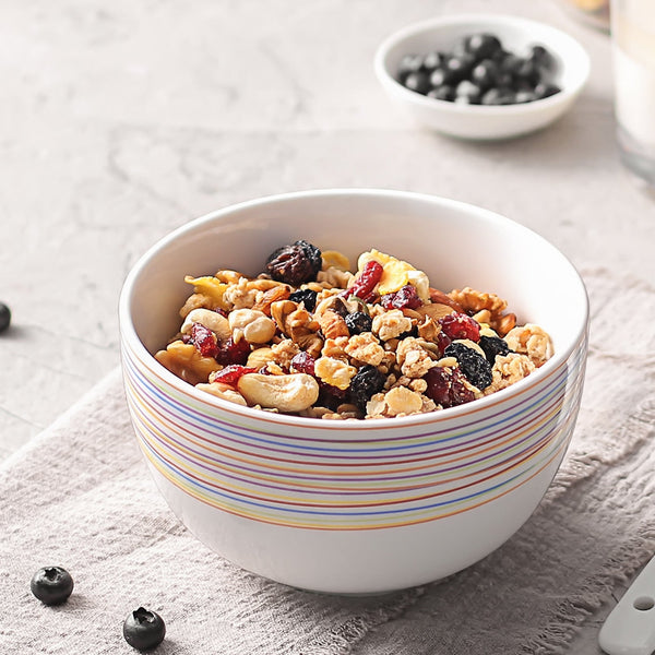 Bowl of granola with berries on a light surface
