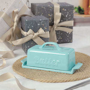 Turquoise butter dish with 'Good & Gather' branding on a table with wrapped gifts in the background.