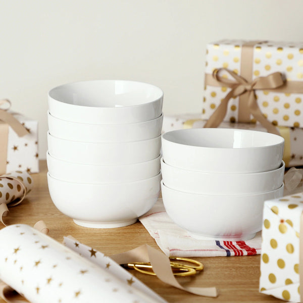 White ceramic bowls on a table with gift-wrapped items in the background