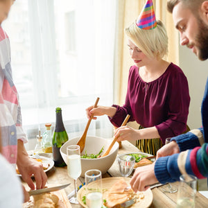 People preparing food together at a table with a festive atmosphere