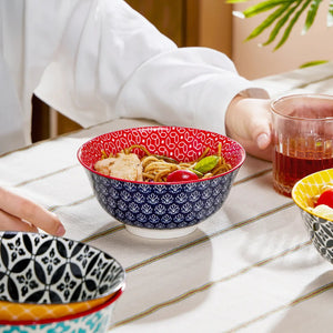 Person sitting at a table with patterned bowls and a glass of tea.