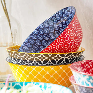 Stack of colorful patterned bowls on a neutral background