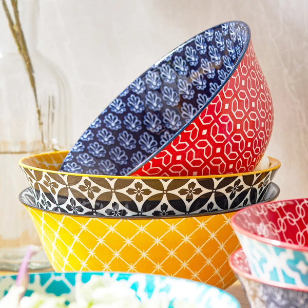Stack of colorful patterned bowls on a neutral background