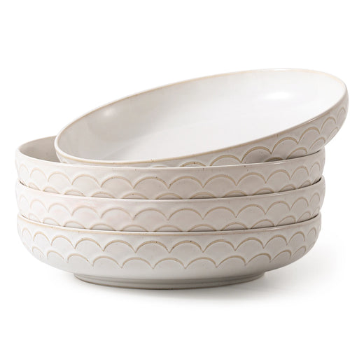 Set of four stoneware pasta bowls with wave pattern on a white background