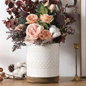 Decorative large utensil crock with pink roses and greenery on a light background