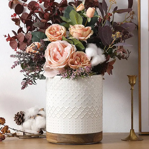 Decorative large utensil crock with pink roses and greenery on a light background