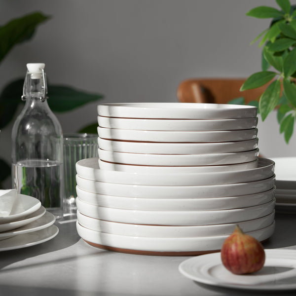Stack of white ceramic plates on a table with a blurred background