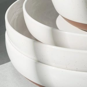 Stack of white ceramic bowls on a gray surface