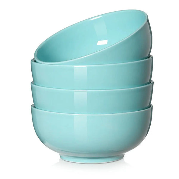 Set of four light blue ceramic bowls stacked on a white background