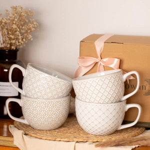 Set of vintage coffee mugs on a wooden surface with a gift box in the background.