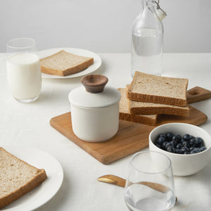 Breakfast setting with toast, milk, and berries on a white surface
