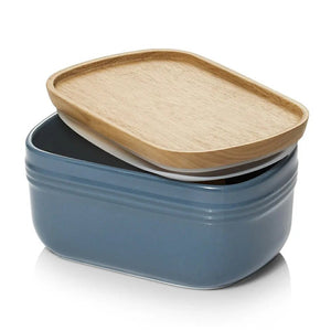 Blue ceramic container with a wooden lid on a white background