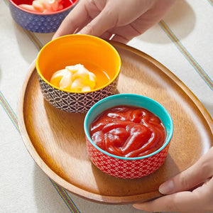 Two small bowls with mayonnaise and ketchup on a wooden plate.
