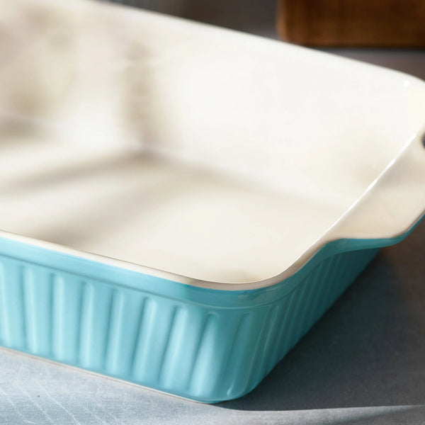 Rectangular baking dish with turquoise bottom and white top on a gray surface