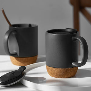 Two beige coffee mugs on a white plate.